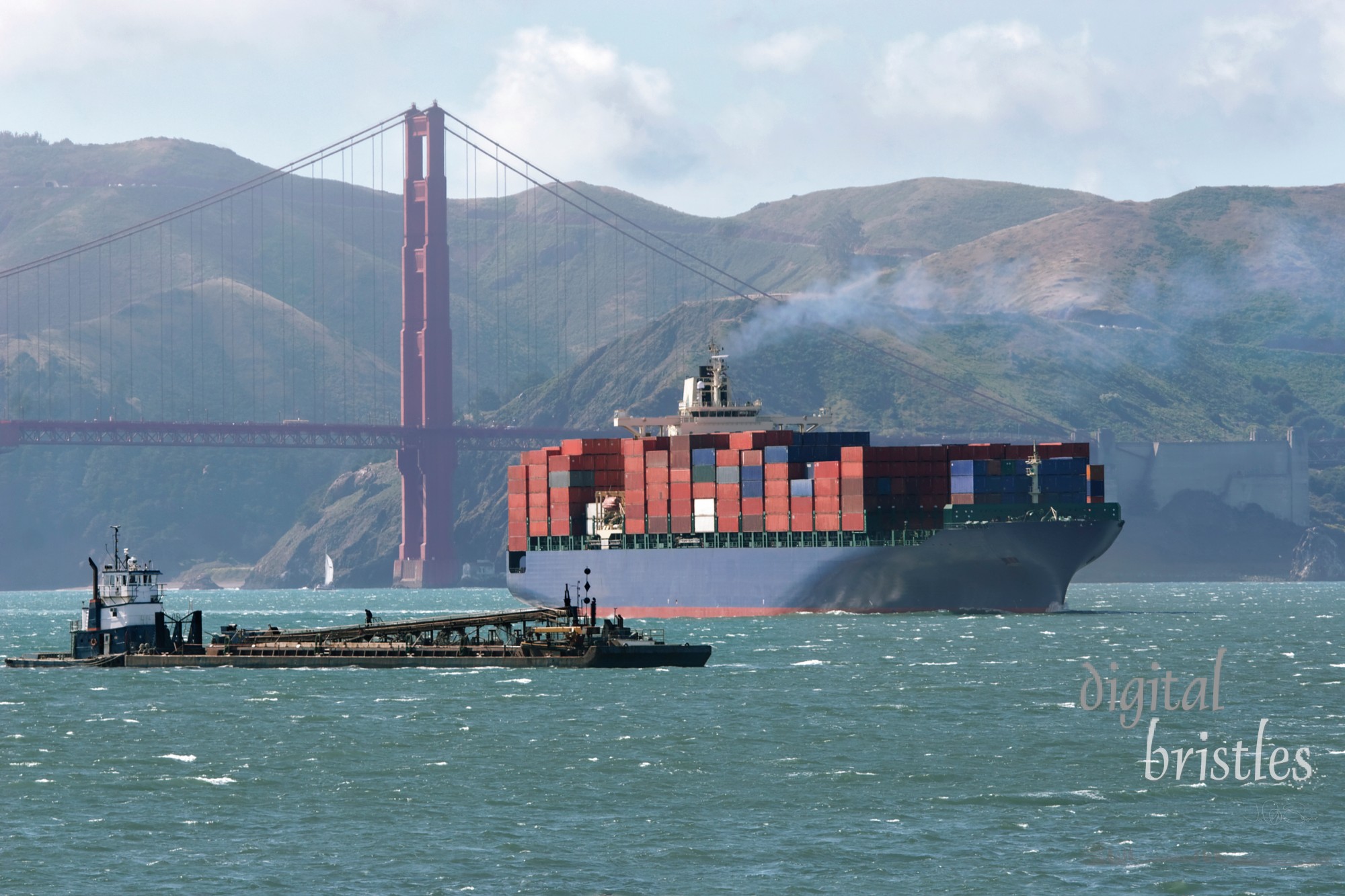 Container ship and barge at work by the Golden Gate Bridge, San Francisco, California