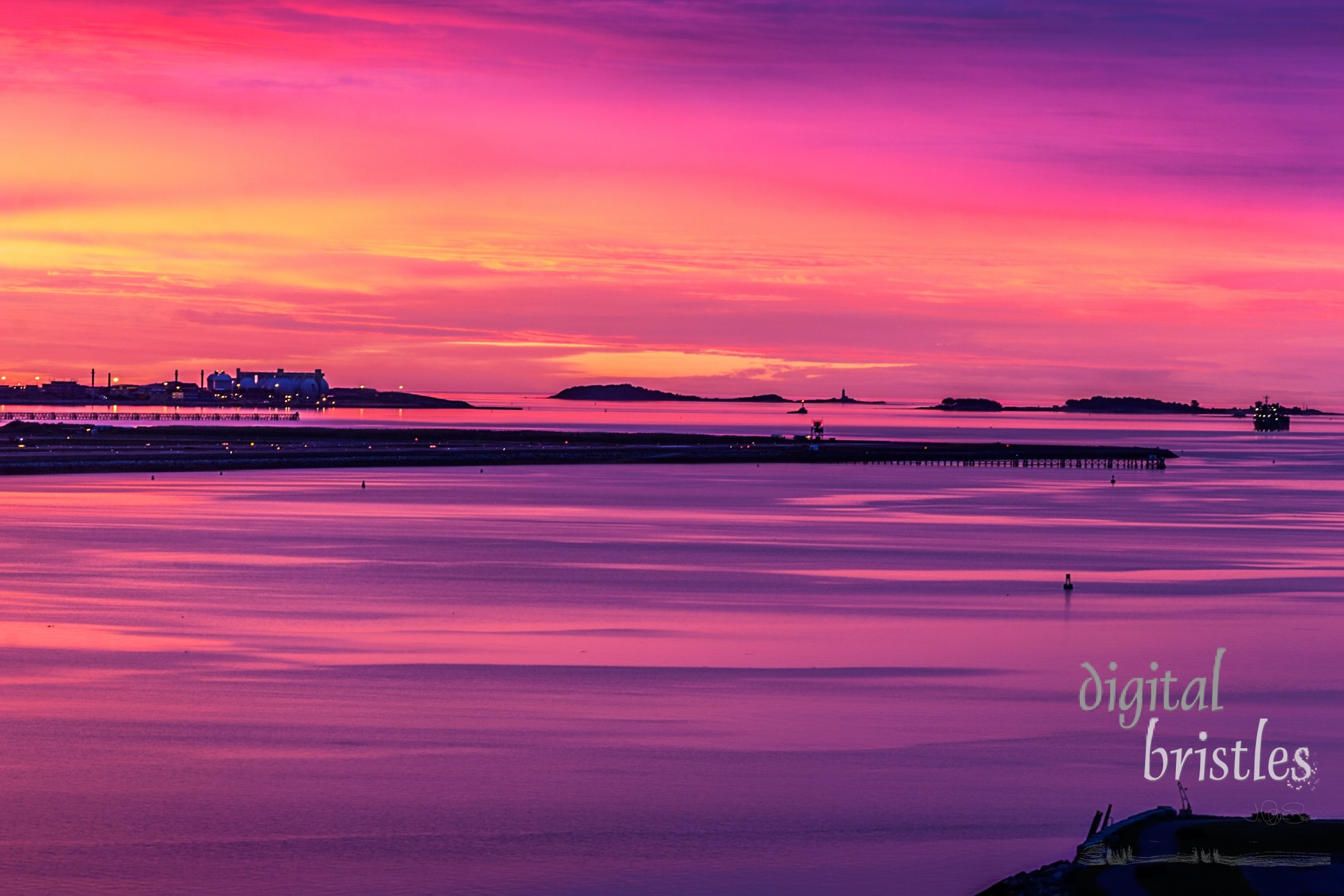 Tip of the runway at Boston's LoganAirport with vivid purple, orange and pink skies just before sunrise on a summer morning