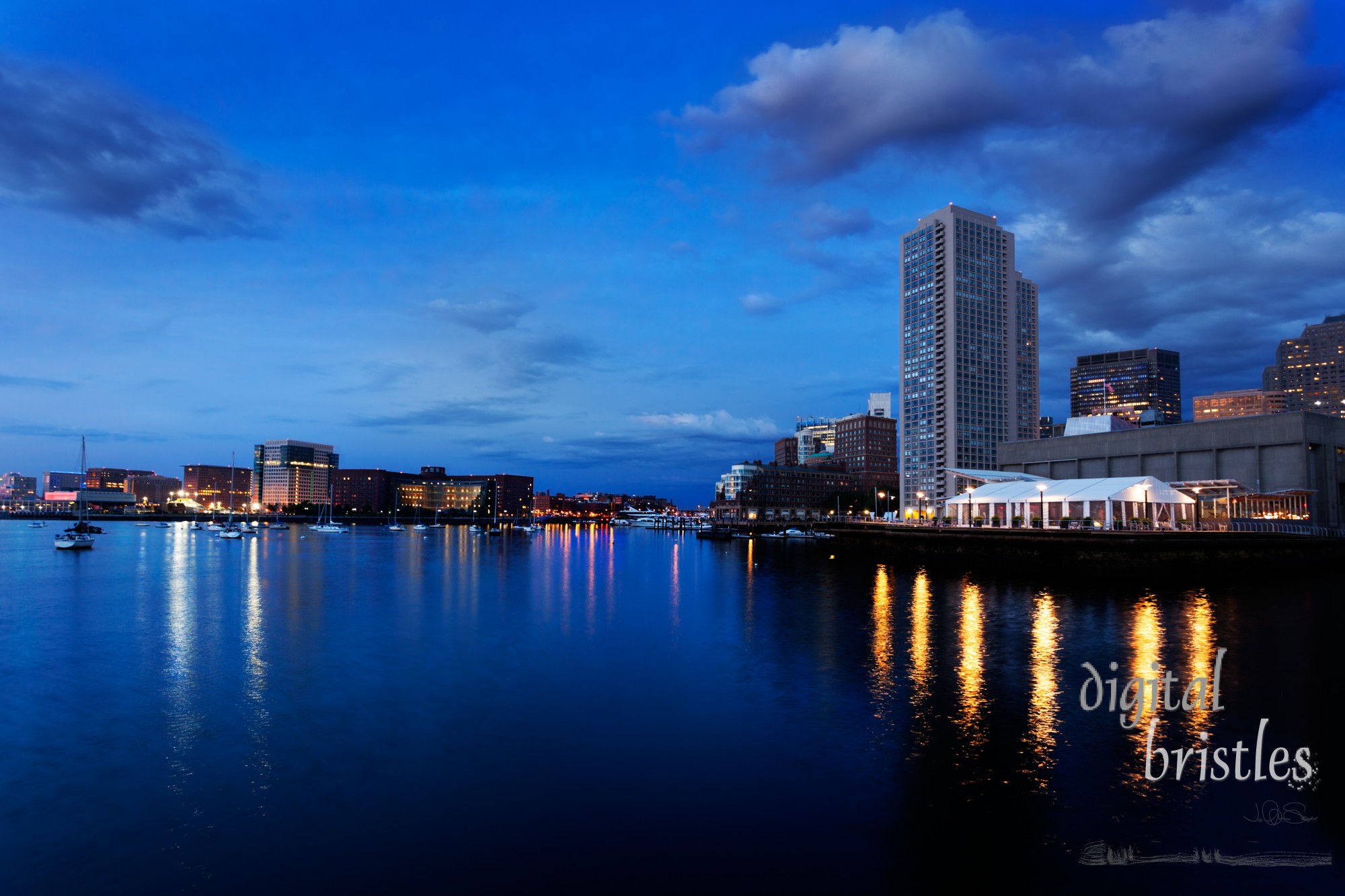 Lights in the dark water of Boston Harbor before the sun rises on a summer morning