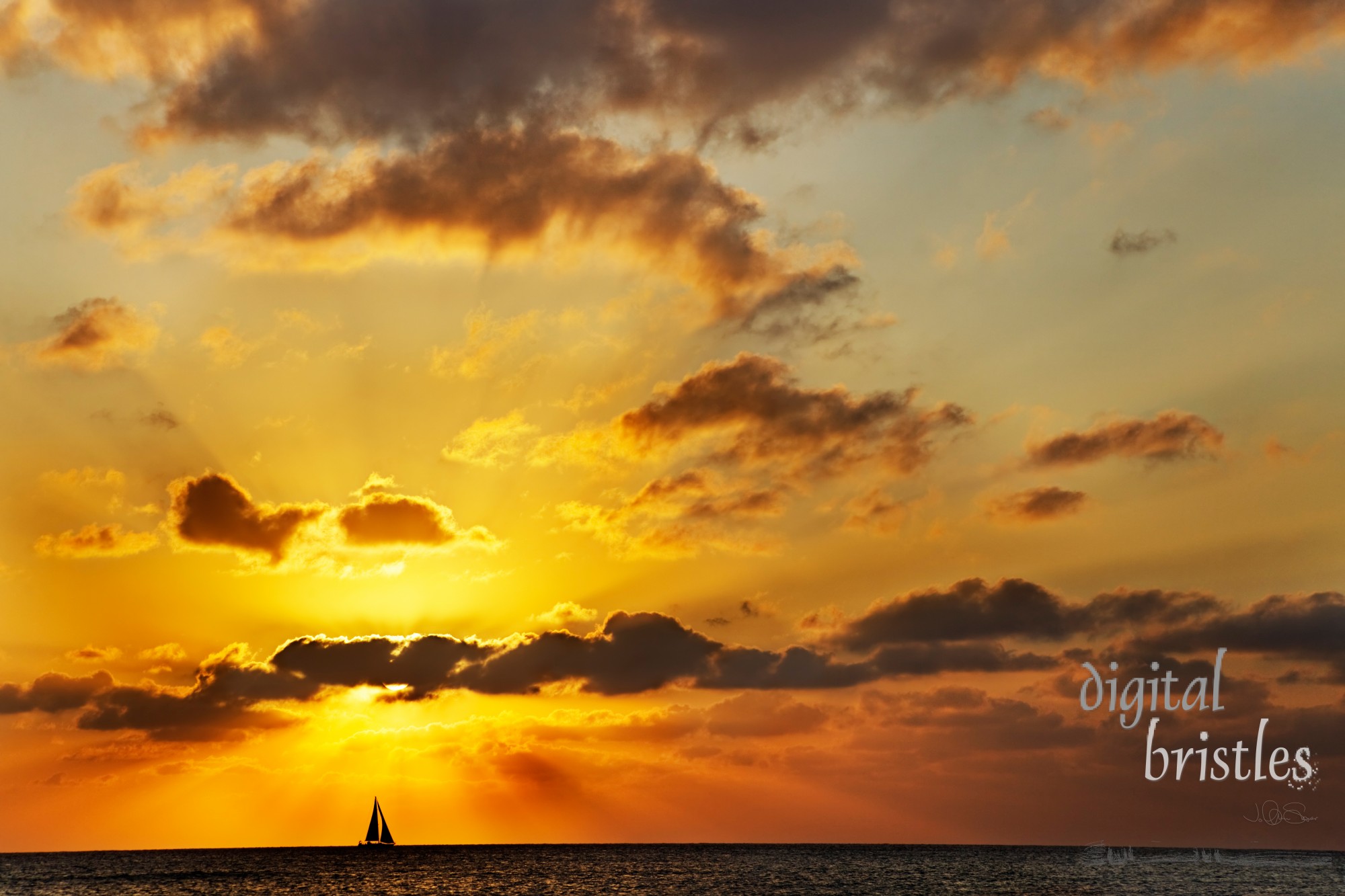 Sailboat at the horizon passes in front of the setting sun