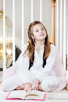 Young girl daydreams while supposed to be reading her book