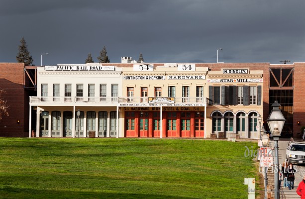 Huntington & Hopkins Hardware Store museum on I Street in Old Sacramento lit by afternoon sun on a stormy day. The museum recreates a mid 19th century hardware store. The Big Four building in which these storefronts are located is named for the 4 businessmen who met here in 1861 to plan a railroad link between East Coast and West.