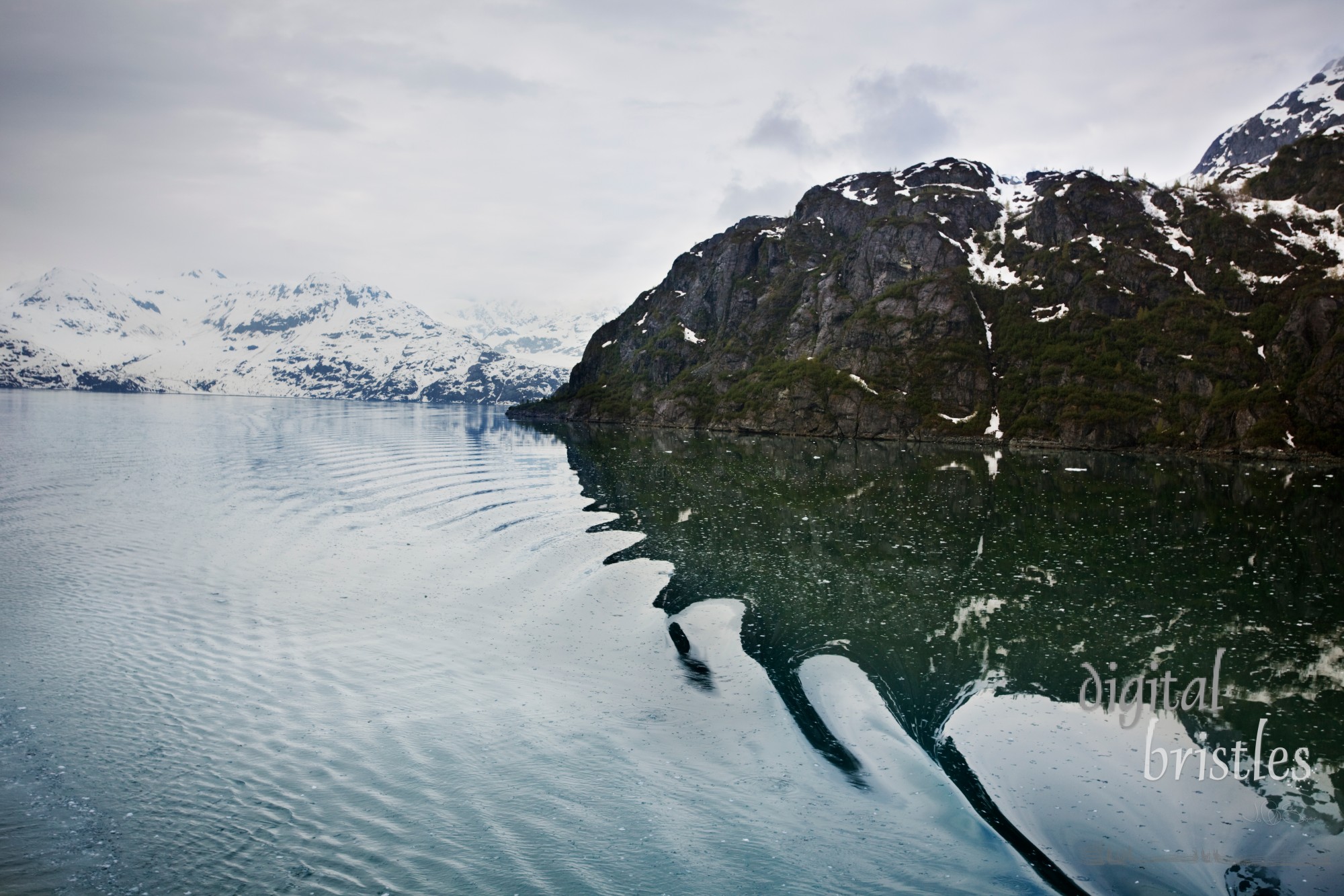 Ripples distort the reflected mountains in Glacier Bay National Park, Alaska