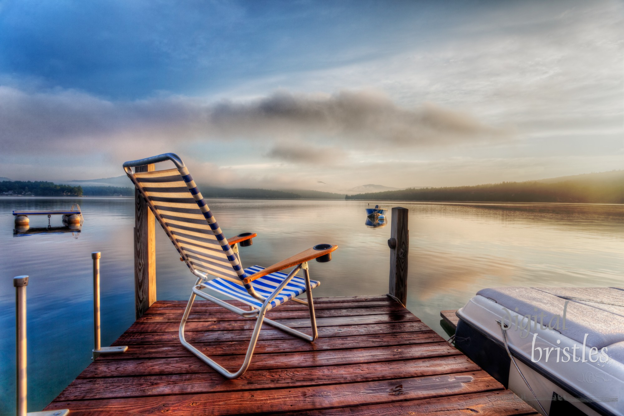 Chair sitting at the end of a dock in very early morning summer light