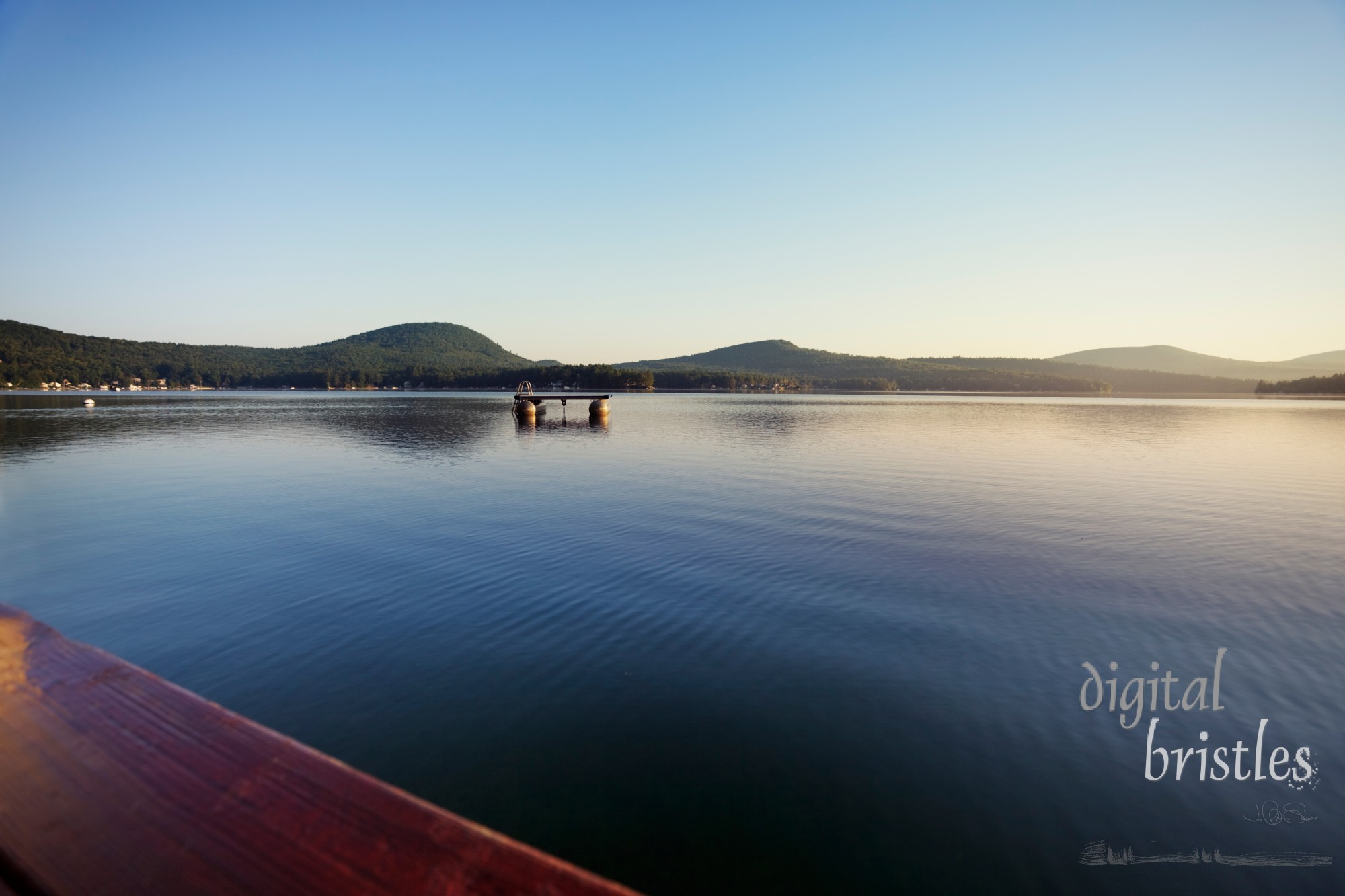 Calm waters on a Summer morning at a New Hampshire lake dock