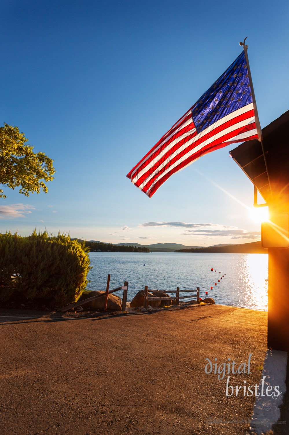 Summer sunrise over Merrymeeting Lake boat ramp with flag flapping in the breeze