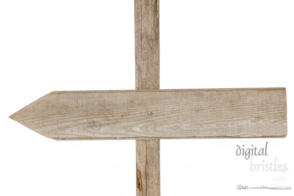 Weathered wood sign nailed to post