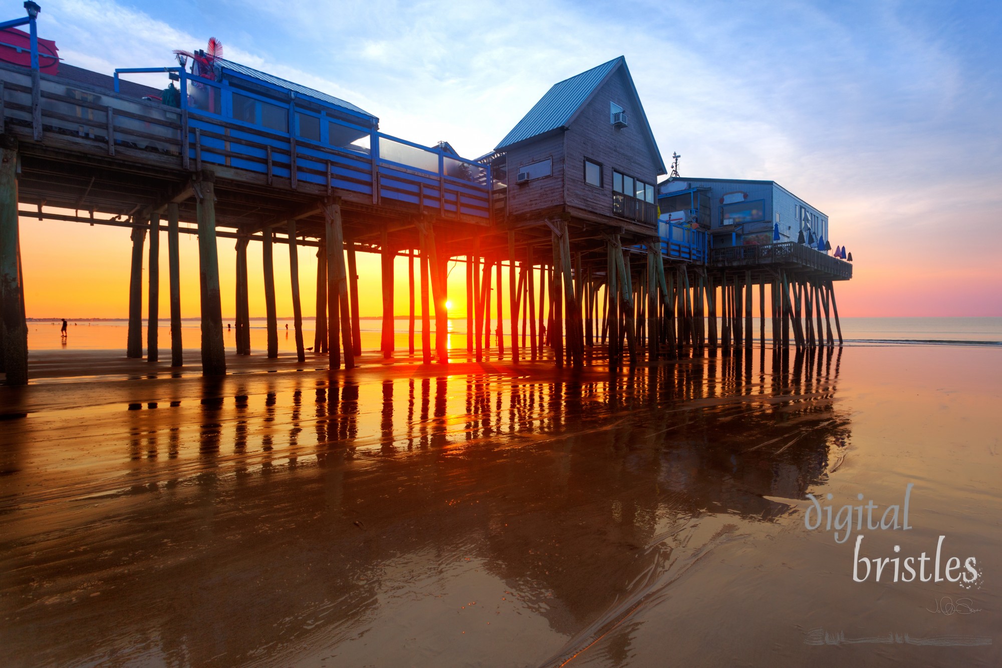 Sun through the pilings under the pier at low tide, Old Orchard Beach Maine