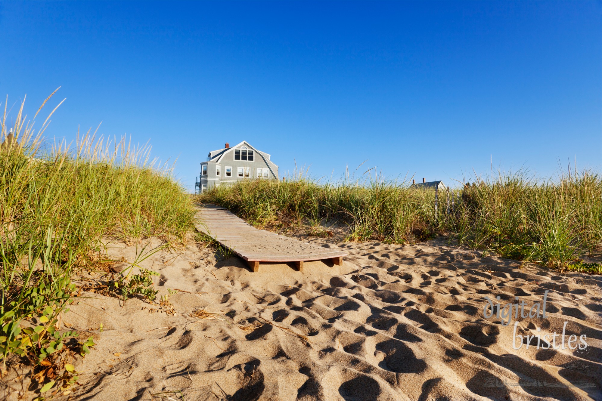 The end of a boardwalk onto a Maine beach, early morning