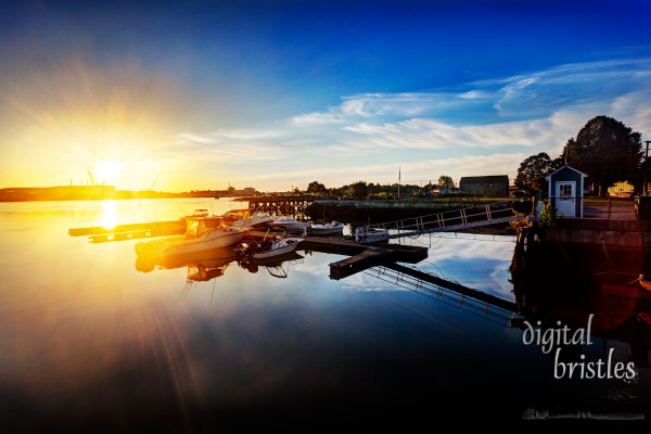 Sun rises over Kittery and the Portsmouth Naval Shipyard as seen from docks at Prescott Park, Portsmouth, New Hampshire