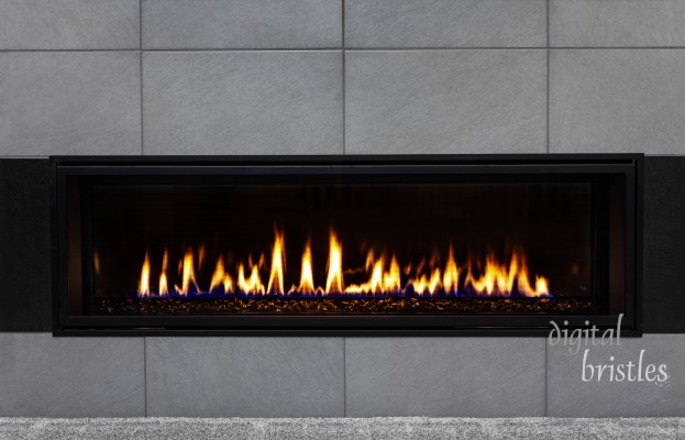 Sleek modern gas fireplace with gray tile surround and black glass media reflecting the flames