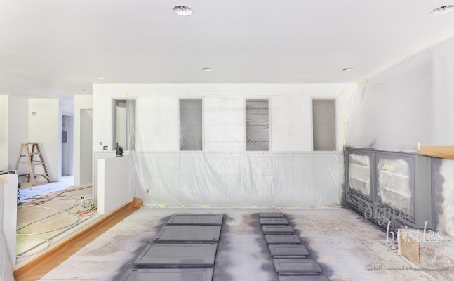 Family room draped in plastic for trim painting